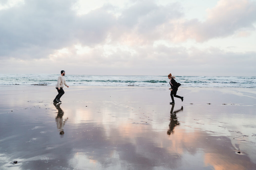 Couples running on the beach in oregon 