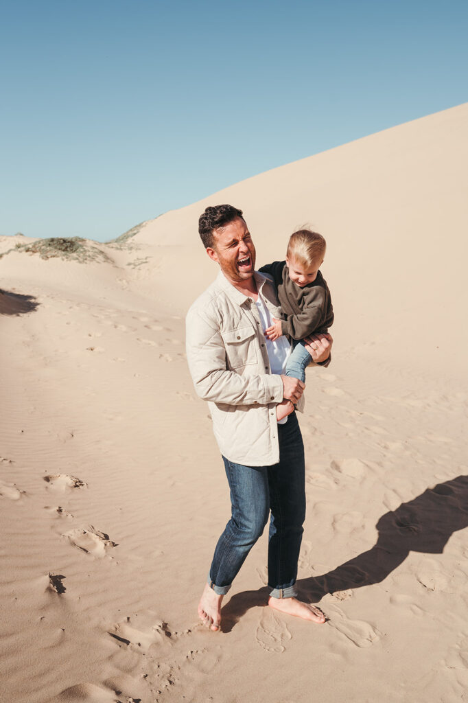 father and son laughing at the beach 