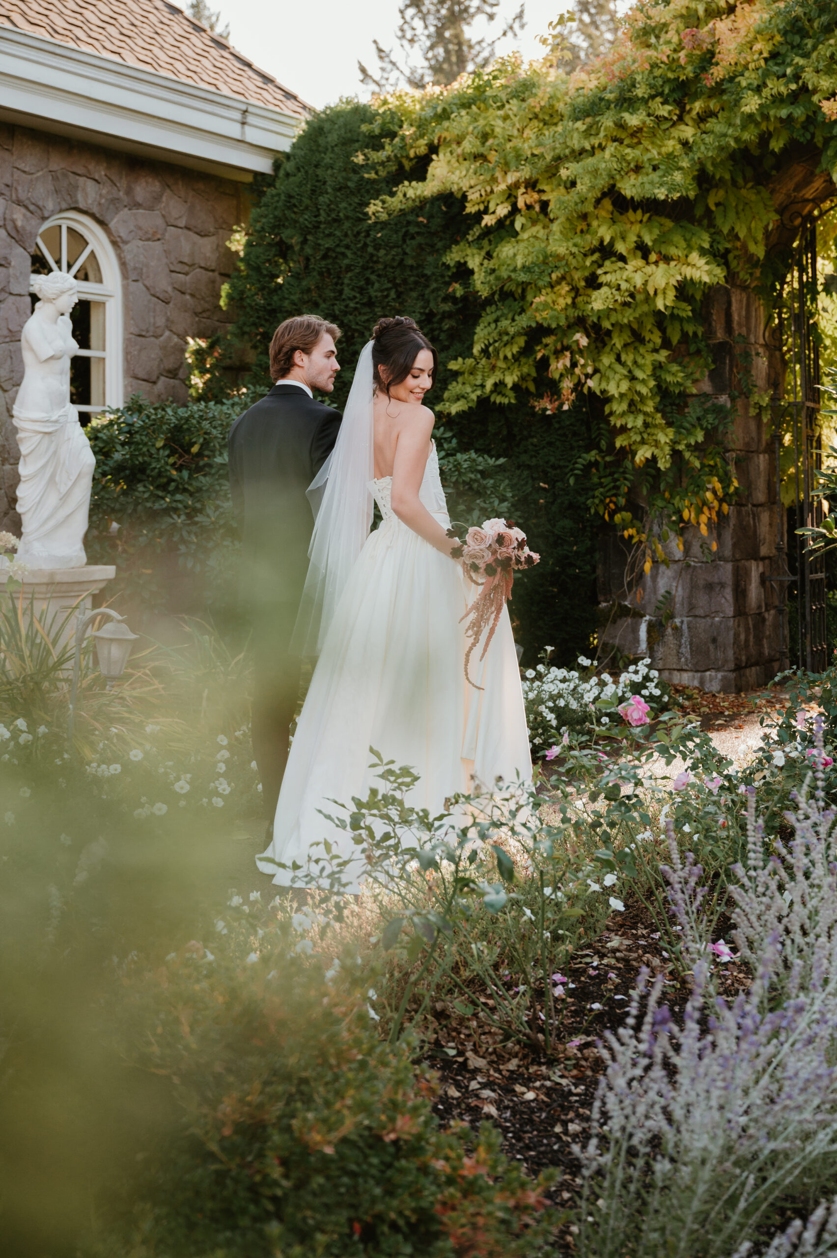 bride and groom walking through flowers at their wedding venue Chateau de michellia