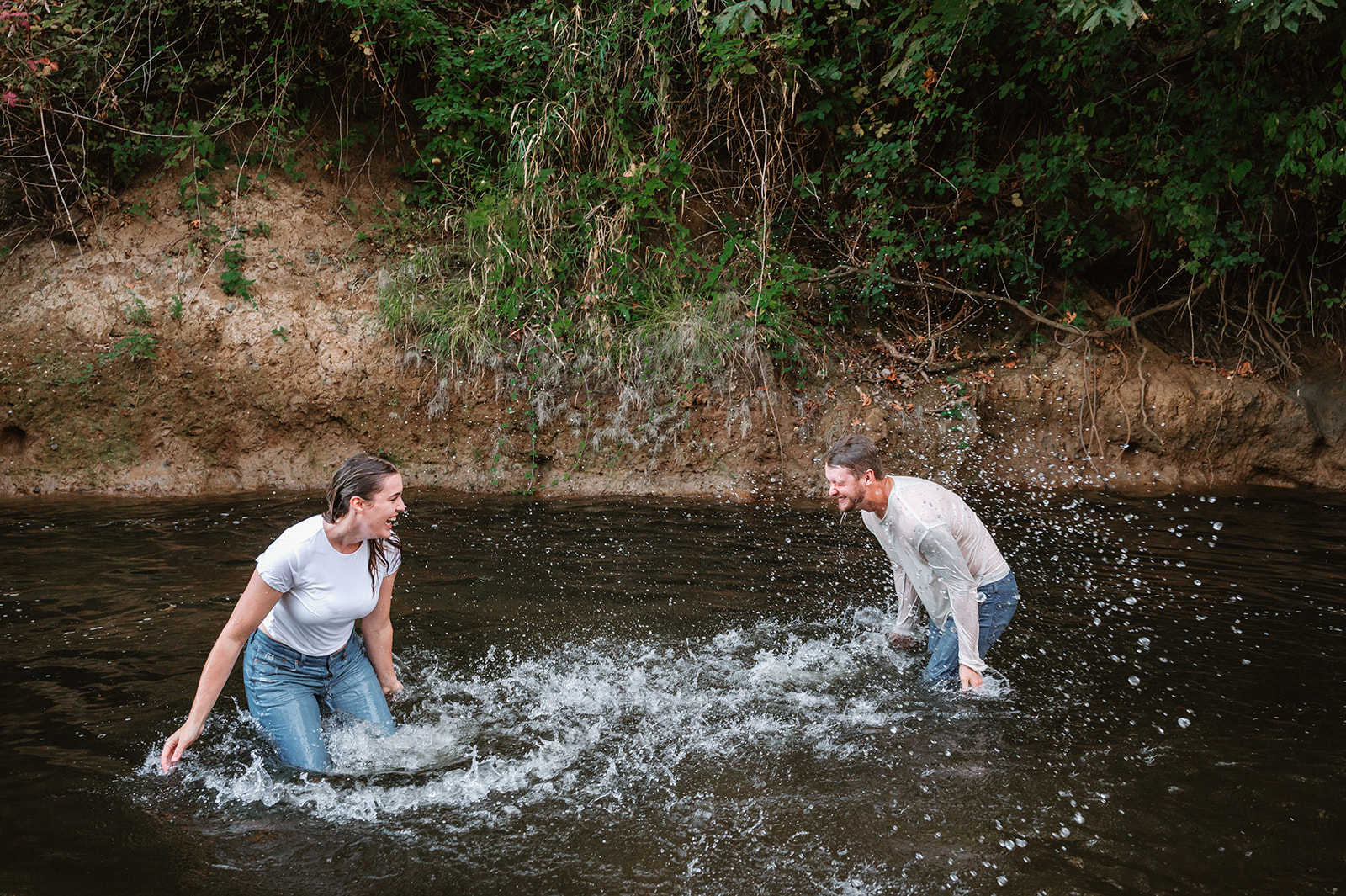 couple playing in the river together 