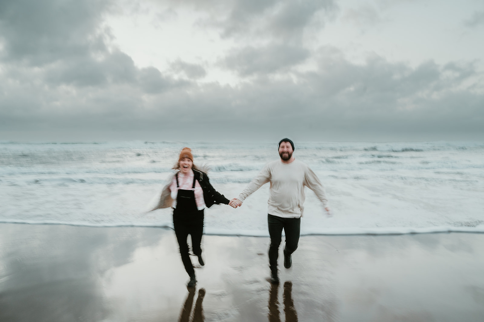 Couple running hand in hand at the beach 