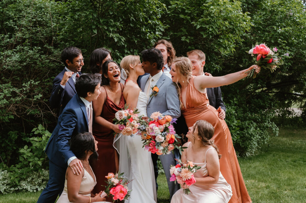 wedding party kissing and laughing having fun during cocktail hour