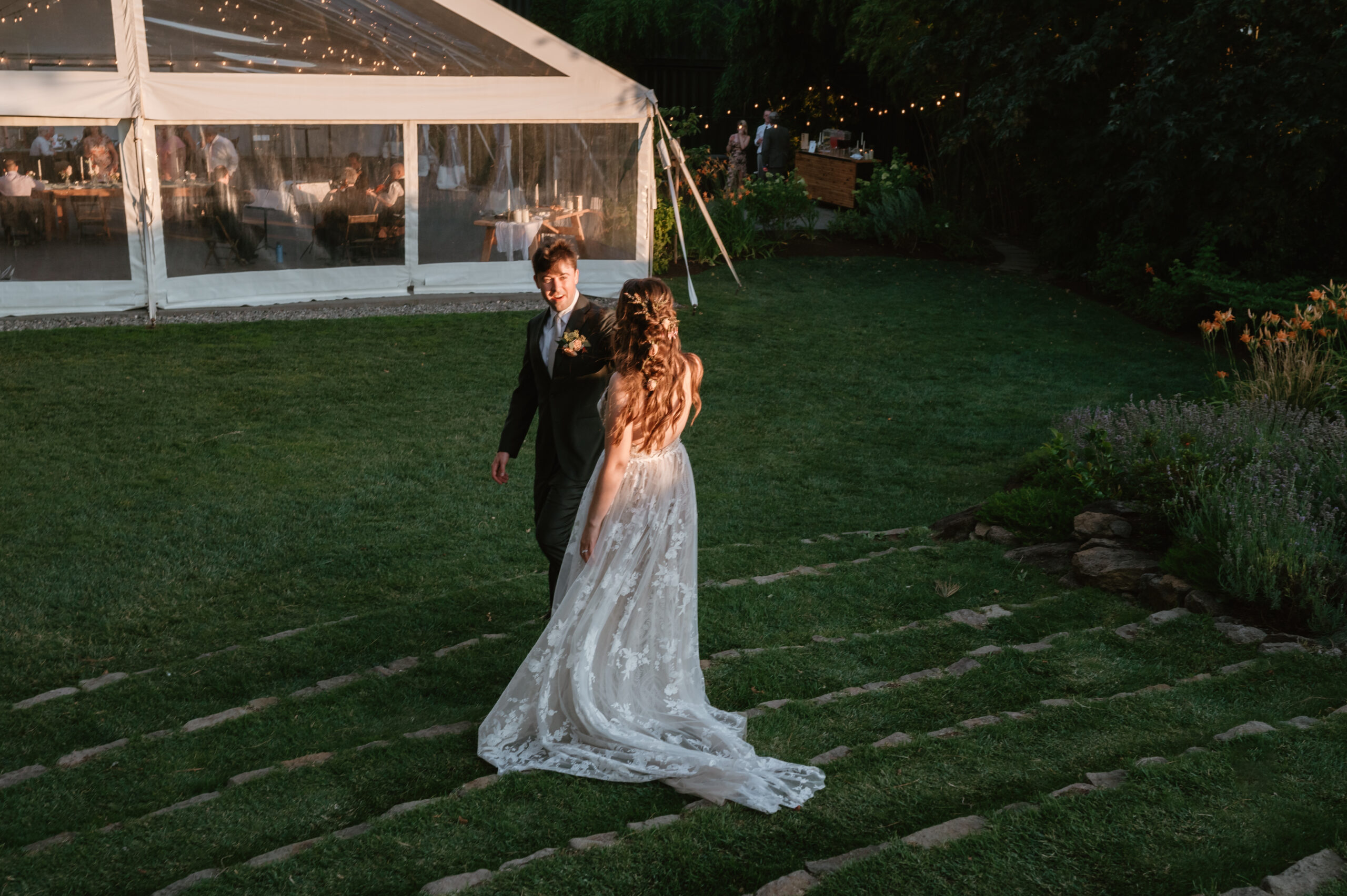 groom leading bride down the stairs at the griffin house towards the reception tent 