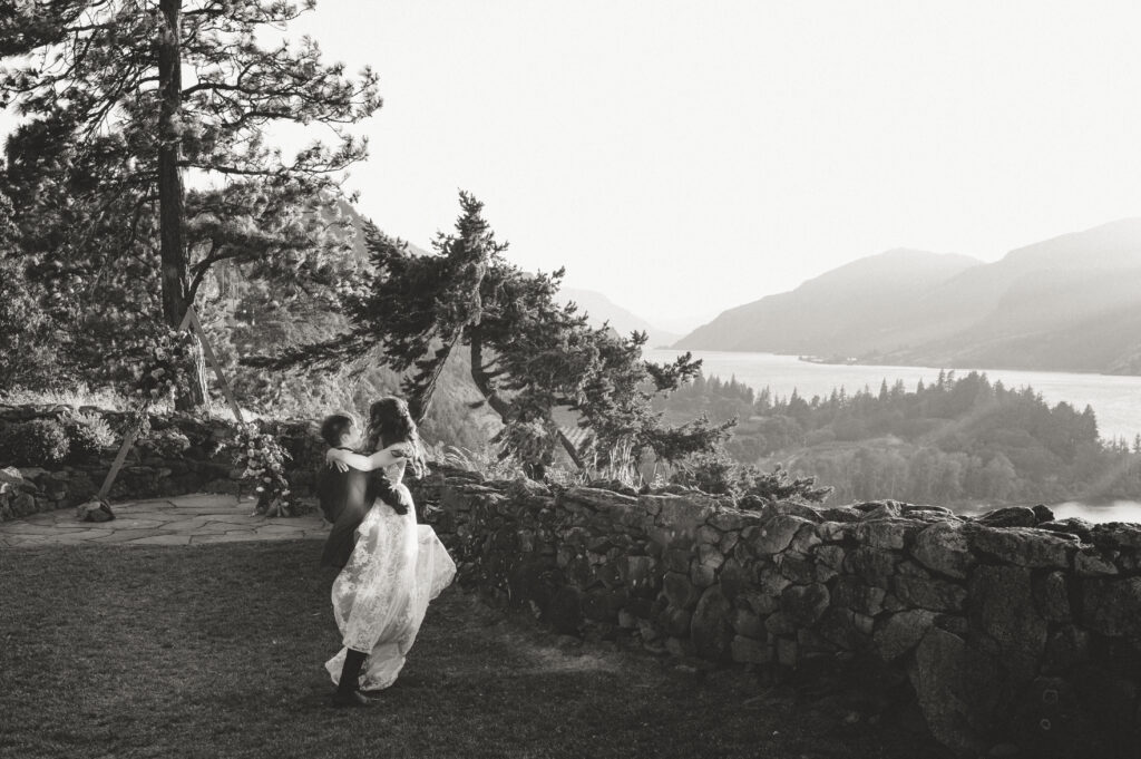 groom twirling bride around during sunset portraits on the cliff in hood river 