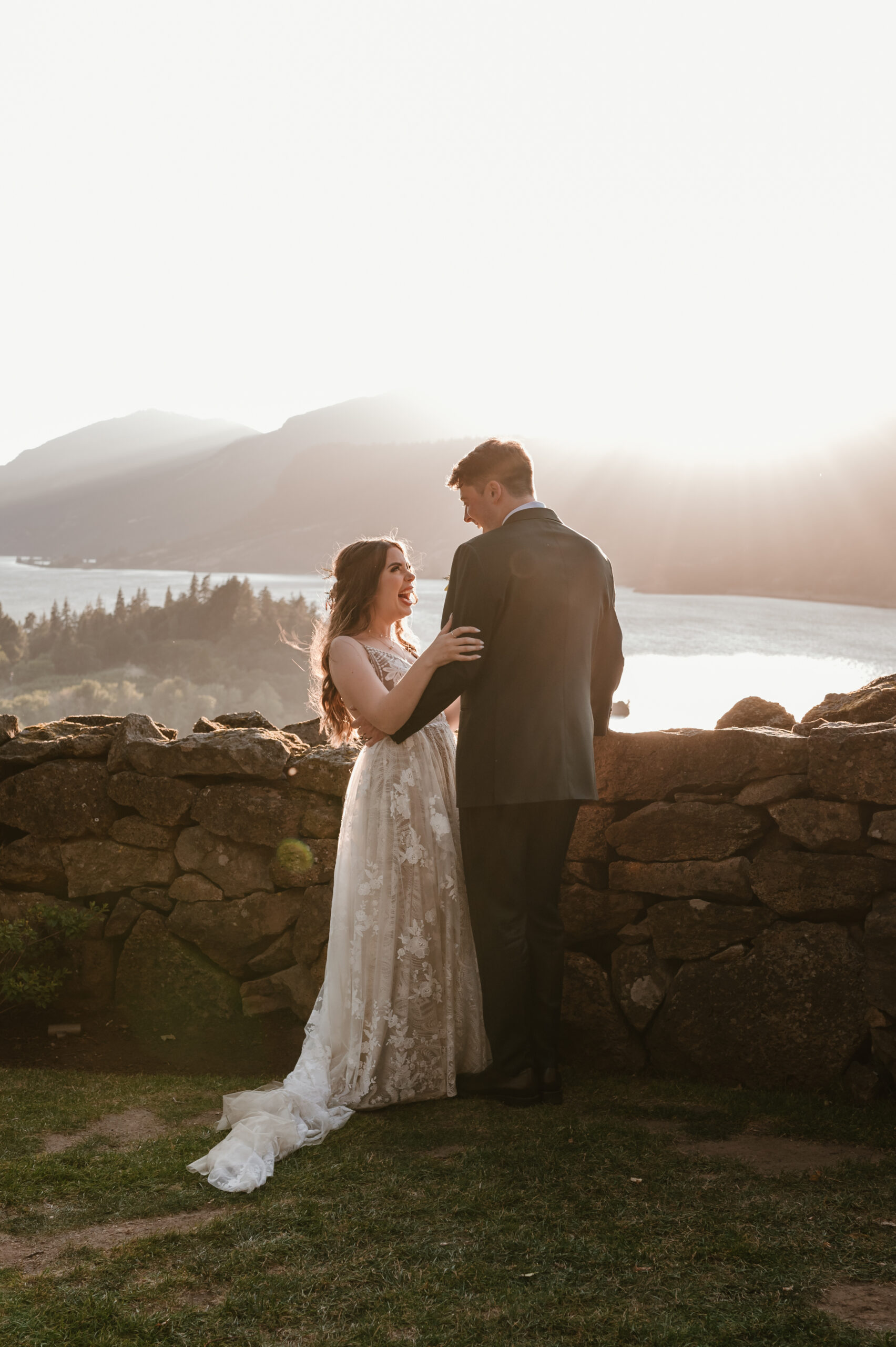 bride and groom laughing together on the cliff near the Columbia River Gorge 