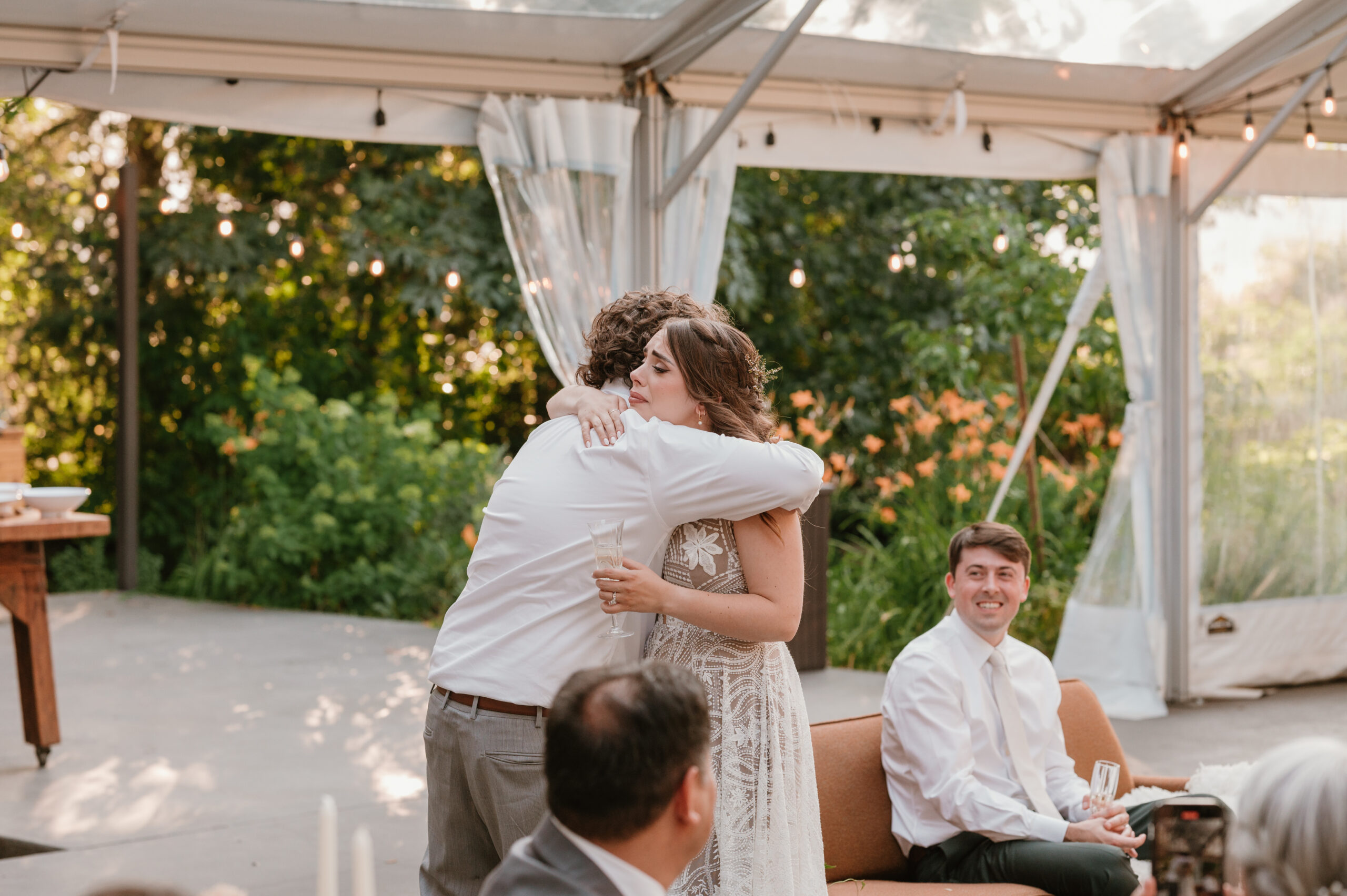 bride hugging borther during wedding toast and cryhing 