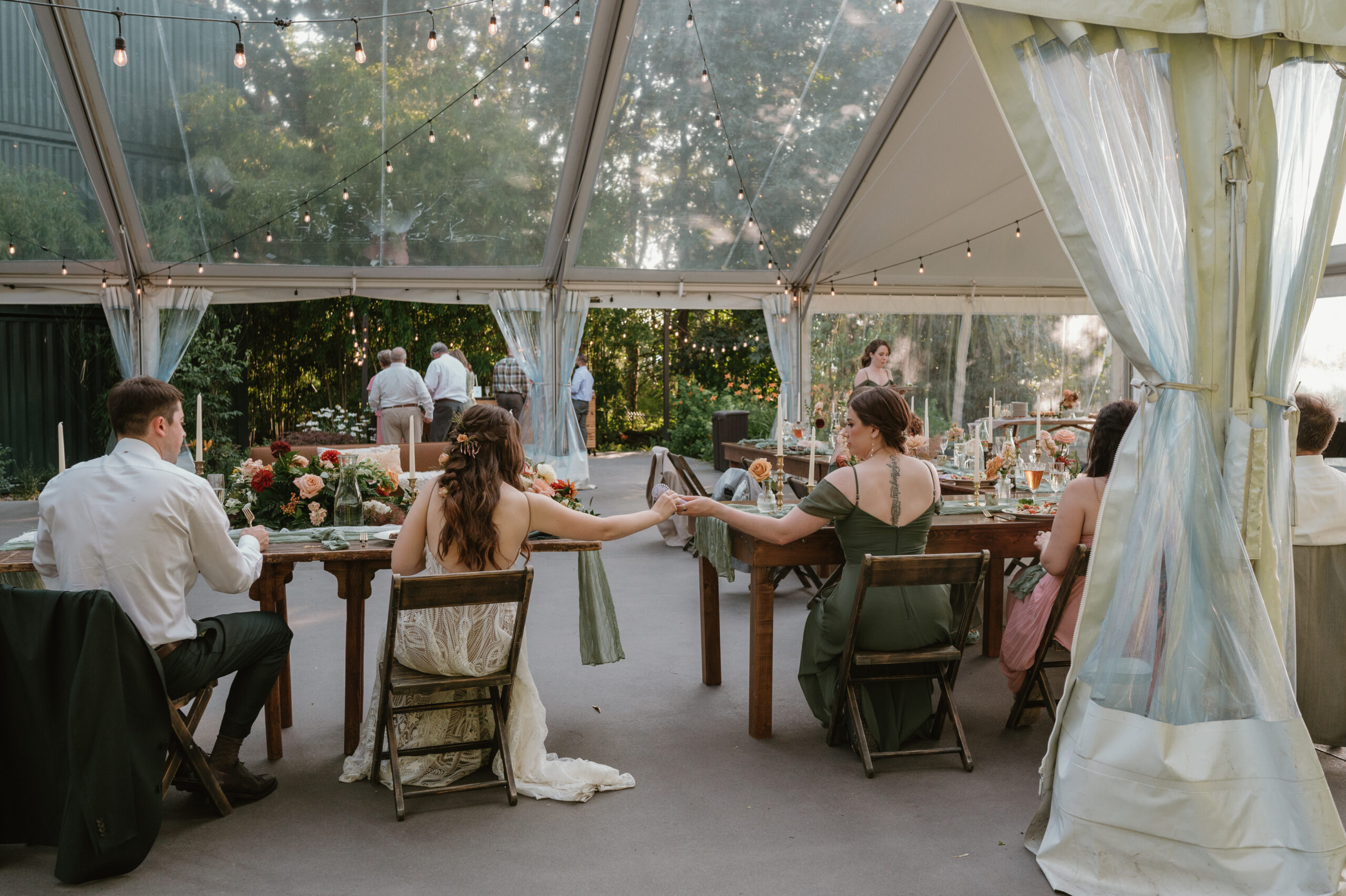 bride reaching out to maid of honor at reception 