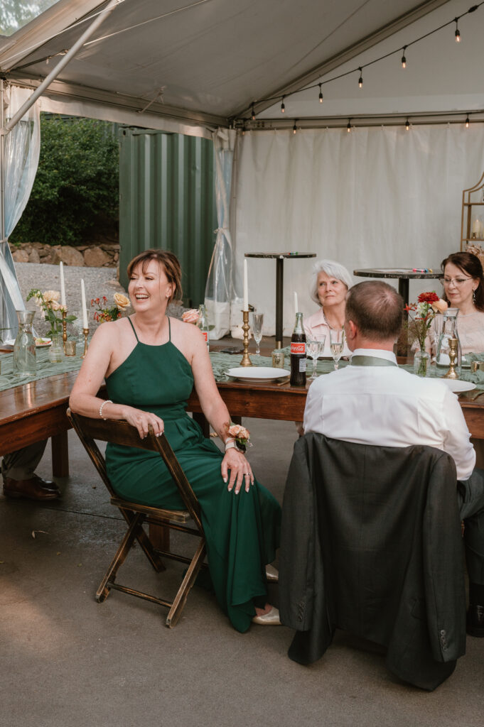 mother of the groom laughing during toasts at reception 