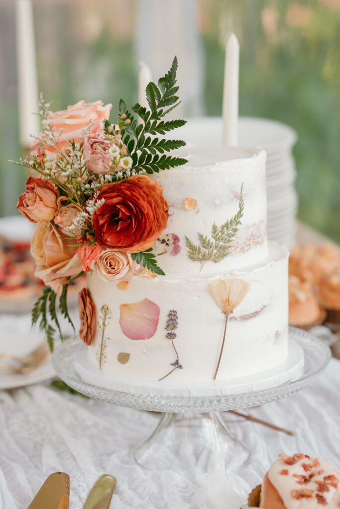 pressed flowers mixed with fresh flowers on a white wedding cake 