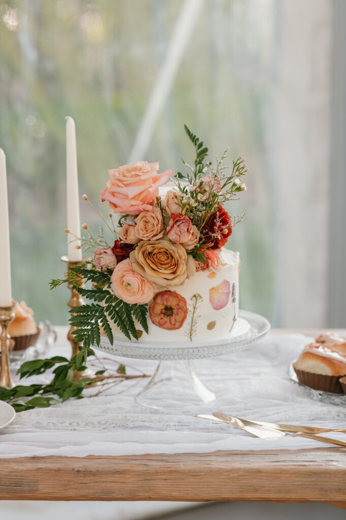 pressed flowers mixed with fresh flowers on a white wedding cake 