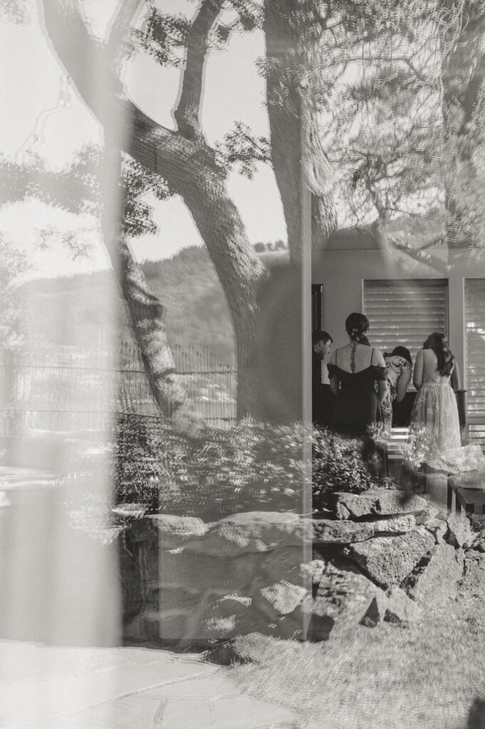 bride and groom signing marriage license through view of window 