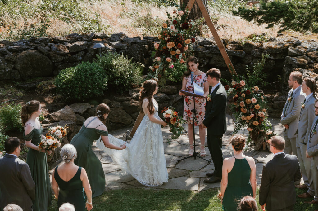 maid of honor fixing brides train during the ceremony 