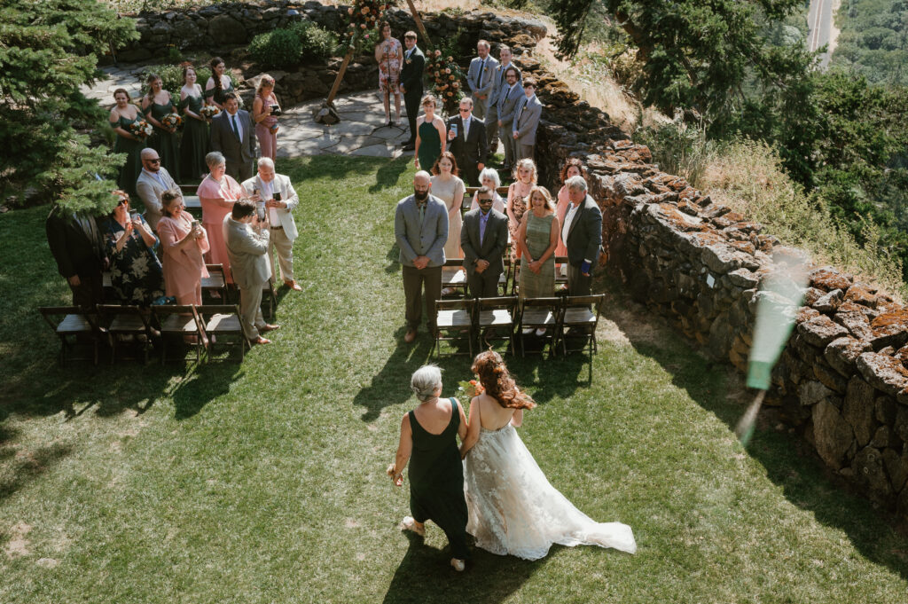 bride walking down the aisle with her mother 