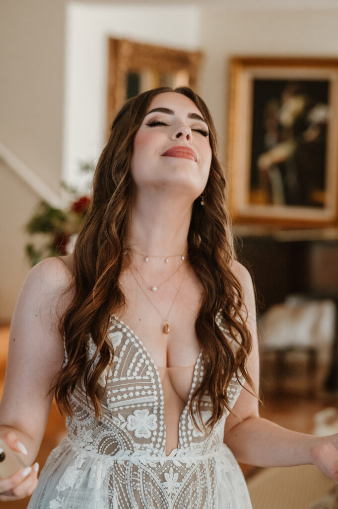 bride in bridal gown putting perfume on 