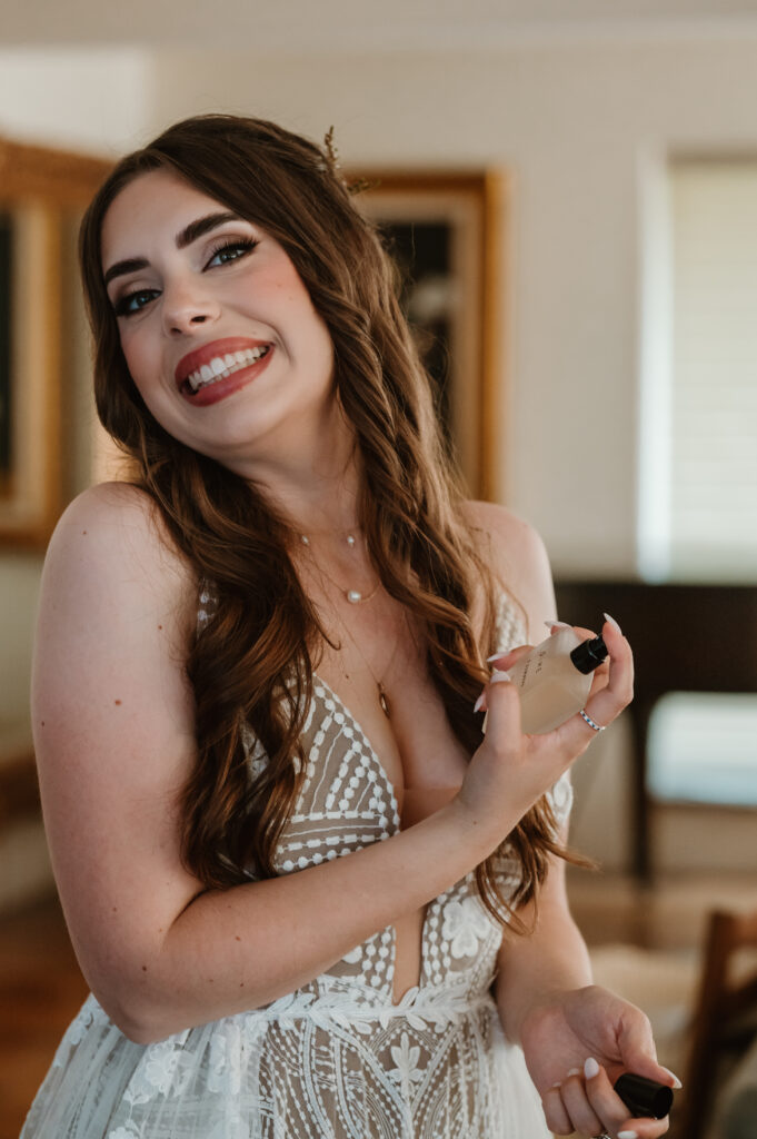 bride putting on perfume before the wedding ceremony 