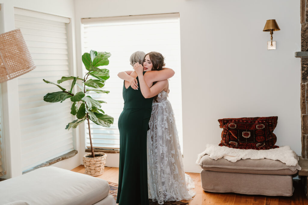 bride and mother of the bride hugging and crying together 