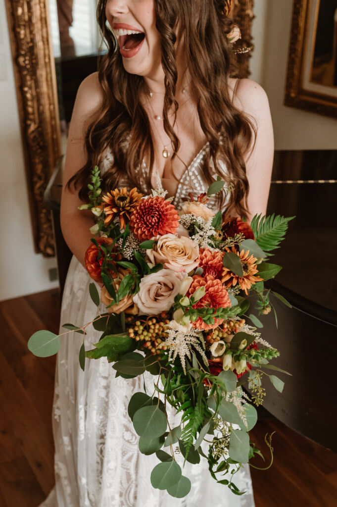 bride laughing while holding bridal bouquet 