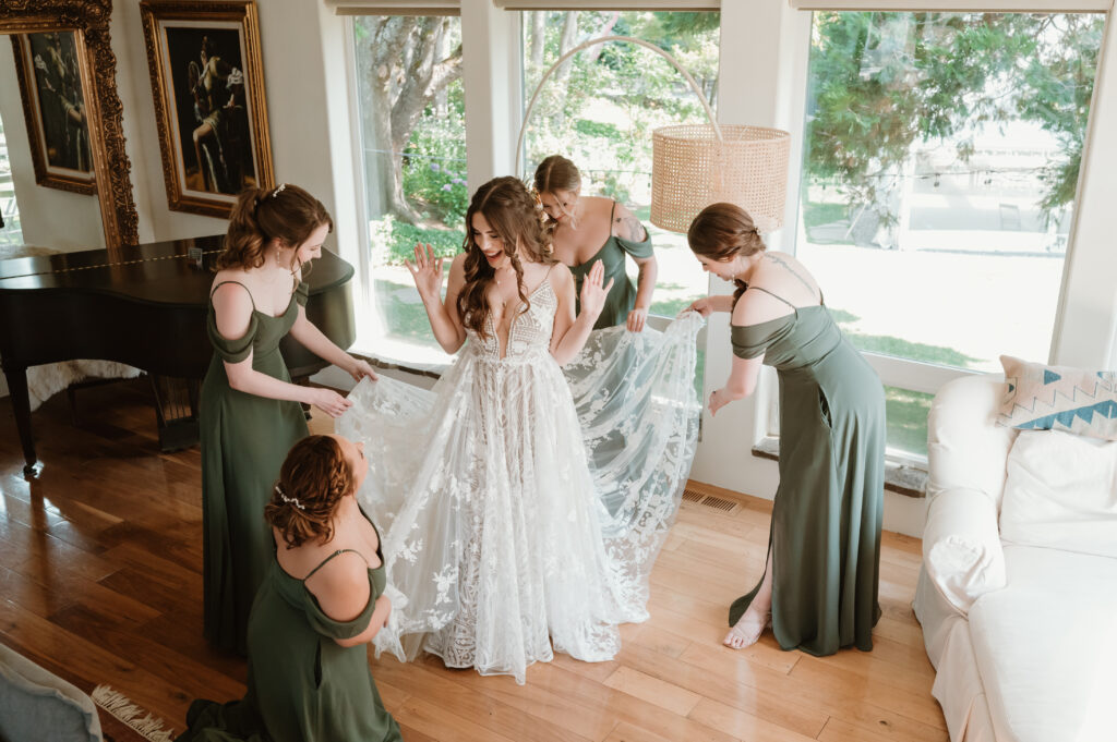 bridal party helping fix brides dress 