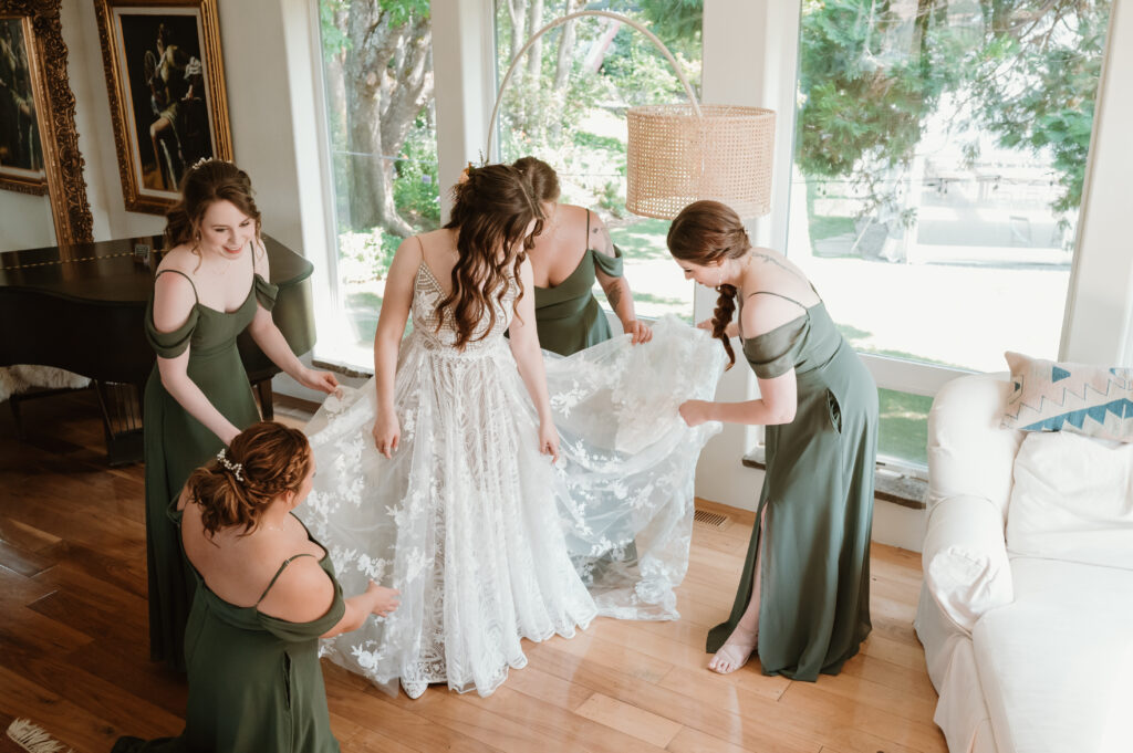 bride and bridal party fixing brides dress