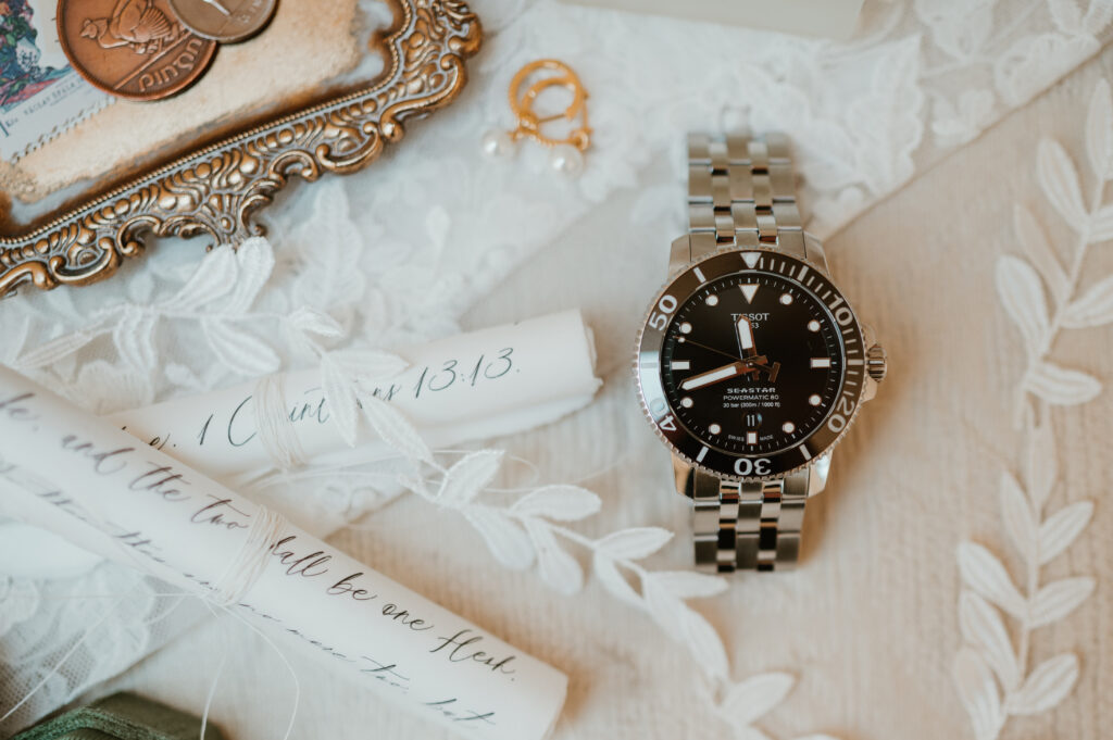 bridal flat lay with grooms watch 