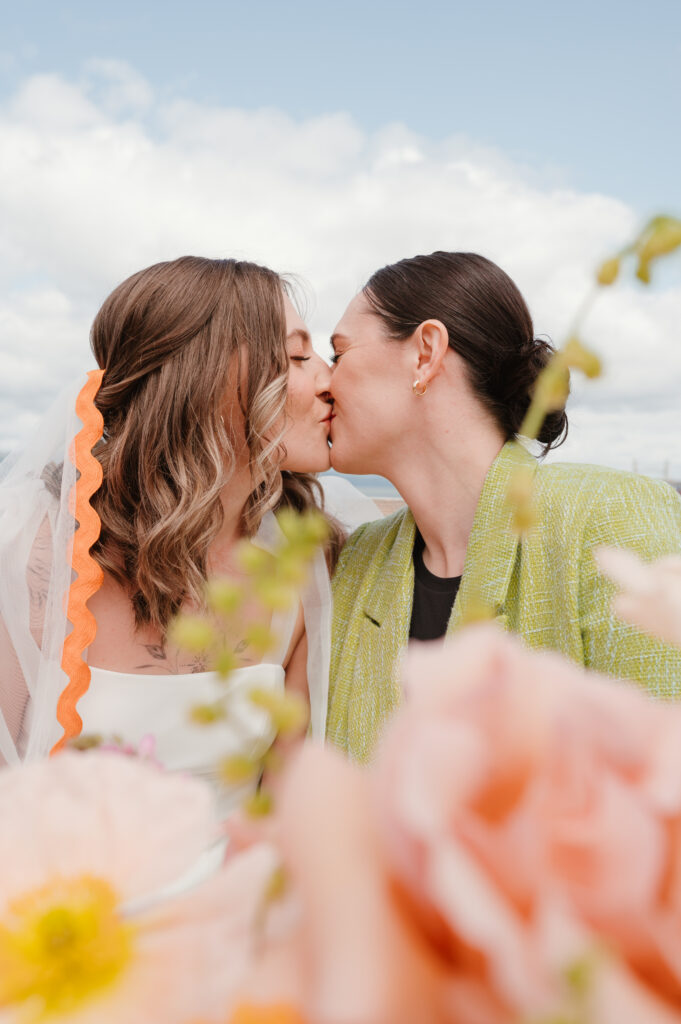 brides kissing at table for toast