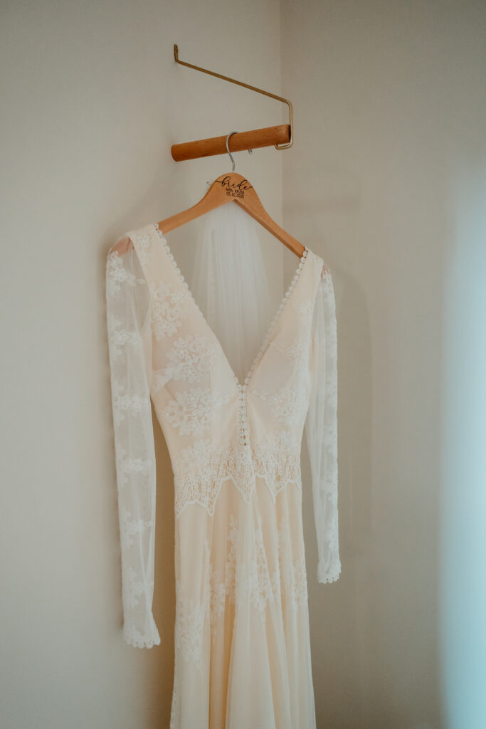 dreamers and lovers lace bridal gown hanging on custom hanger 