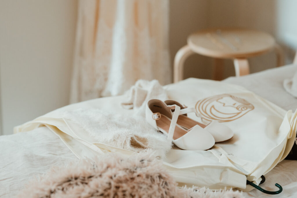 brides daughters shoes and dress sitting on the bed 