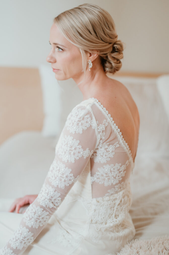 Bride looking out the window of her getting ready suite during her intimate oregon coast wedding 