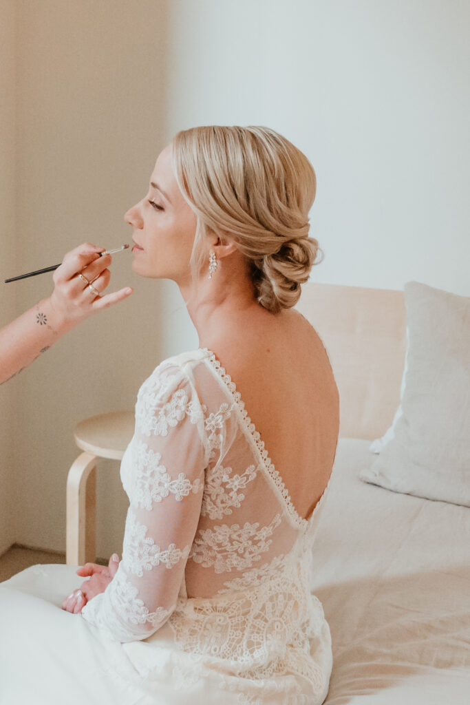 Bride getting lipstick touched up before her first look 