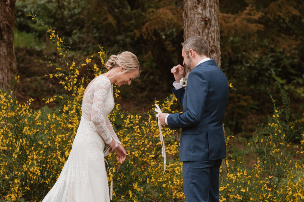 Couple sharing a laugh during their private vows at their intimate coastal wedding 
