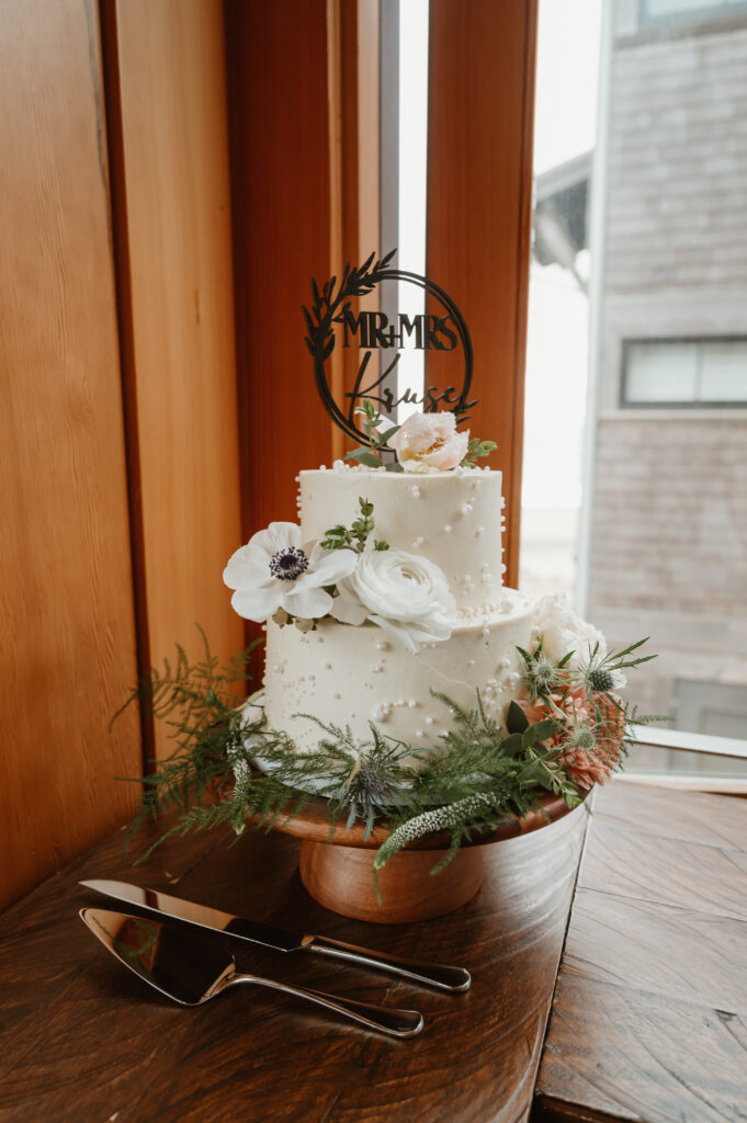 small two tiered cream wedding cake with florals 
